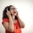 Photo of Singing Woman in Red Top and Black Framed Eyeglasses Listening to Music on Her Headphones